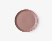En rund, flad tallerken med en glat, mat overflade i en afdæmpet støvet rosa farve. Tallerkenen har en let hævet kant og et minimalistisk, moderne design uden mønstre eller dekorationer.