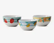 Sæt med tre keramiske skåle, hver med unikt håndmalet frugtmotiv og farverige vandrette striber. Én skål har røde jordbær med grønne blade på turkise striber, en anden har gule citroner med grønne blade på lyseblå striber, og den tredje viser orange ferskner med grønne blade på gule striber. Skålene har en blank overflade og rund form, velegnet til servering eller omrøring.