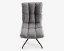 Stol med høj ryg og moderne design, betrukket med gråt, tekstureret stof. Sædet og ryglænet er opdelt i store, kvadratiske, polstrede sektioner for ekstra komfort og et stilfuldt udtryk. Stolen står på en sort metalbase med skråtstillede ben, hvilket giver stabilitet og et moderne udseende.