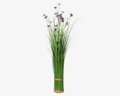 Høj dekoration med kunstige grønne græslignende stilke, små lilla blomster og fine hvide detaljer, samlet i bunden med en naturfarvet snor. Stilkenes lange og slanke form giver et luftigt og opretstående udtryk, velegnet til gulv eller stor vase.