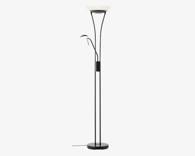 Høj, moderne gulvlampe med sort metalfod og stang. Lampen har to lyskilder: en stor, opadrettet skålformet lampe øverst til generel belysning og en mindre, justerbar læselampe med buet arm placeret halvvejs oppe på stangen. Begge lamper har hvide diffusere for blødt lys. Der er en fodkontakt på ledningen for nem betjening.