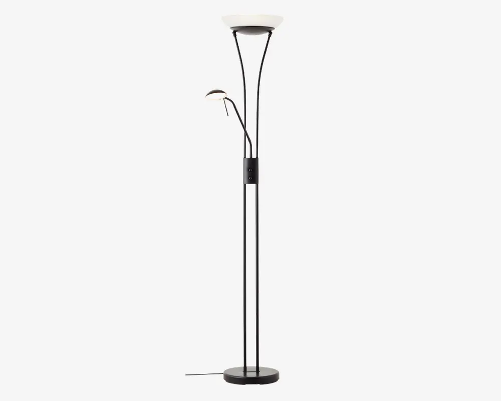 Høj, moderne gulvlampe med sort metalfod og stang. Lampen har to lyskilder: en stor, opadrettet skålformet lampe øverst til generel belysning og en mindre, justerbar læselampe med buet arm placeret halvvejs oppe på stangen. Begge lamper har hvide diffusere for blødt lys. Der er en fodkontakt på ledningen for nem betjening.