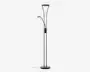 Høj, moderne gulvlampe med sort metalfinish og rund base for stabilitet. Lampen har to lyskilder: en stor, opadrettet hovedlampe øverst og en mindre, justerbar læselampe monteret på siden. Begge lamper har matterede hvide skærme, der giver blødt lys. Lampen har en synlig ledning og en kontrolknap på hovedstangen.