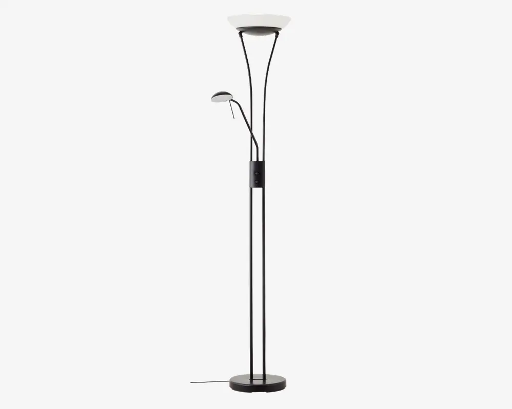 Høj, moderne gulvlampe med sort metalfinish og rund base for stabilitet. Lampen har to lyskilder: en stor, opadrettet hovedlampe øverst og en mindre, justerbar læselampe monteret på siden. Begge lamper har matterede hvide skærme, der giver blødt lys. Lampen har en synlig ledning og en kontrolknap på hovedstangen.
