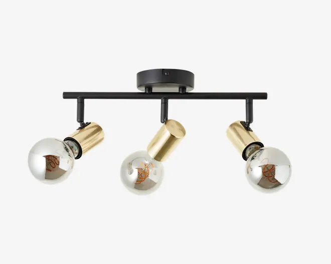 Loftmonteret lampe med tre justerbare spotlys. Hver spot har et cylindrisk hus i guldfarvet metal og er udstyret med en rund, dekorativ glødepære. Lampen er monteret på en sort, vandret stang og en rund, sort loftsroset, hvilket giver et moderne og elegant udtryk.