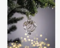 Klar glaskugle med et fint guldfarvet hjerte-design indeni, toppet med en lille glasfinial og ophæng. Kuglen er rund og har en lille glasperle i bunden, hvilket giver et elegant og festligt udtryk.