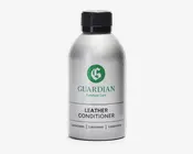 En sølvfarvet plastflaske med sort skruelåg, der har et grønt 'G'-logo og mærket 'Guardian Furniture Care' trykt i grønt. Etiketten viser også 'Leather Conditioner' med fed sort skrift, samt yderligere tekst på flere sprog nederst. Flasken har et enkelt, moderne design og ser ud til at være nem at holde og hælde af.