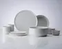 Et sæt minimalistisk, mat hvidt keramikstel bestående af to store middagstallerkener, to mindre sidetallerkener, en dyb serveringsskål, to mellemstore kopper med lige sider og to små skåle. Designet er moderne med rene linjer og en glat, enkel overflade, hvilket giver et tidløst og elegant udtryk, der passer til mange forskellige borddækninger.