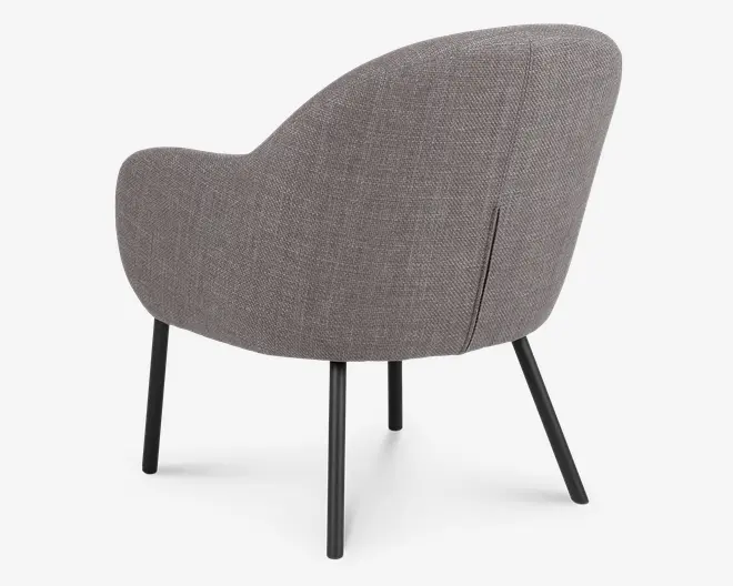 Billedet viser bagsiden af en moderne stol med rundet, buet ryglæn og armlæn. Stolen er polstret med et tekstureret, lysebrunt stof og har fire slanke, sorte metalben, der er let udadskrånende for stabilitet. Betrækket har en diskret lodret syning ned langs ryggen.