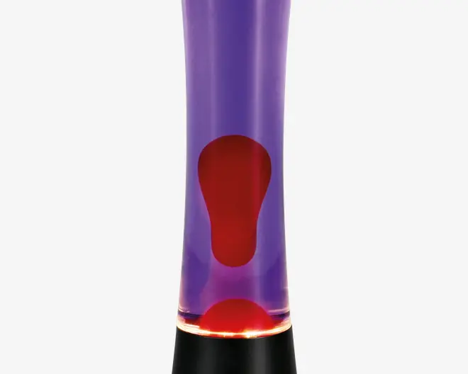 En cylindrisk lampe med sort fod og top, der har en klar glasbeholder fyldt med lilla væske og rød voks. Voksen danner organiske, flydende former, når den bevæger sig i væsken, når lampen opvarmes, hvilket skaber en dynamisk og farverig visuel effekt. Lampen udsender et blødt, stemningsfuldt lys fra bunden.