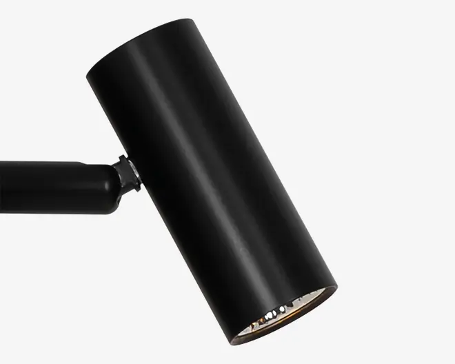 Sort cylindrisk armatur med mat finish og et skråt, justerbart hoved monteret på en kort arm, med en glat minimalistisk overflade og åben frontkant.