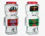To klare glasdrikkeautomater med røde skruelåg og sølvfarvede haner. Hver automat er formet som en tinsoldat og dekoreret med farverige motiver: den ene har en blå og rød uniform med en gylden krone, mens den anden har en grøn og rød uniform med en sort hat med en rød stjerne. Begge har malede ansigter med overskæg, hvilket giver dem et festligt og finurligt udtryk.