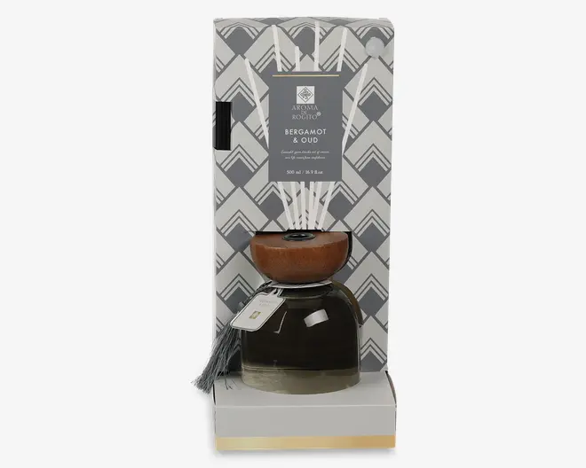 Gavesæt med en mørk glasdiffuserflaske, træprop, sorte pinde og et hængemærke, præsenteret i en geometrisk mønstret æske mærket Bergamot & Oud.