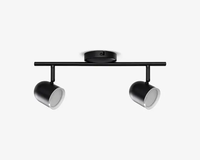 Moderne loftmonteret armatur med to justerbare cylindriske spotlys i mat sort finish. Hvert spotlys kan drejes og vinkles individuelt for fleksibel lysretning. Armaturet har et slankt, minimalistisk design med en rund base og en lige, vandret stang, der bærer lamperne. Indersiden af spotlysene er hvid, hvilket forbedrer lysrefleksionen.