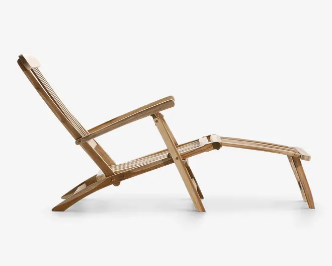 Sidebillede af en loungestol i træ med lameldesign, let tilbagelænet sopryg, brede armlæn og en forlænget fodstøtte sop giver fuld kropsstøtte. St soplen har en naturl sop træfinish og en robust, vinklet ramme, velegnet til udendørs eller terrassebrug.
