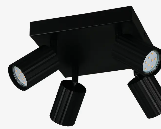 Moderne loftarmatur med fire justerbare cylindriske spots, hver med sort finish og riflede detaljer. Spotsene er monteret på en firkantet base, hvilket giver mulighed for retningsbestemt belysning. LED-pærerne er synlige inde i hver spot og giver energieffektiv belysning. Velegnet til moderne interiør og rum, der kræver fokuseret lys.