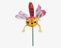 En fantasifuld havepynt formet som et tegneserieagtigt insekt med en rund gul og orange krop, store udtryksfulde øjne og et smilende ansigt. Den har to lyserøde og hvide vinger med sorte årer, en rød segmenteret hale og to gule arme med åbne hænder. Dekorationen er monteret på en tynd metalpind, så den nemt kan placeres i jorden.