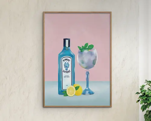 Indrammet kunstværk med en blå flaske med hvid etiket, et stort cocktailglas fyldt med is og pyntet med mynteblade samt en skåret citron foran. Baggrunden har en blød pink og blå farveovergang, hvilket giver værket et moderne og frisk udtryk.