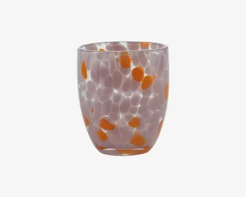 Kort tumbler med afrundet form, lavet af gennemsigtigt glas dekoreret med uregelmæssige orange pletter og hvide prikker. Glasset har en glat overflade og et moderne, kunstnerisk design, hvilket gør det velegnet til servering af drikkevarer i et stilfuldt miljø.