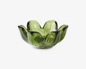 Grøn glasskål med et kronbladsformet design, bestående af seks afrundede, opadbuede sektioner, der ligner blomsterblade. Glasset er gennemsigtigt med en blank overflade, hvilket giver skålen et dekorativt og elegant udtryk.