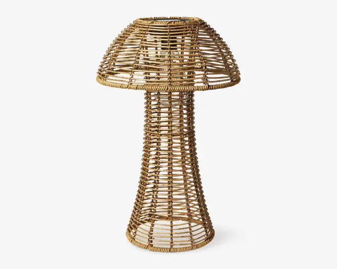 Et dekorativt element fremstillet af naturlig rattan, formet som en svamp med en bred, rund top og en høj, udvidet fod. Det åbne fletdesign lader lys og luft passere igennem, hvilket giver et let og luftigt udtryk. Rattanen er tæt flettet i kanterne for ekstra holdbarhed og stabilitet.