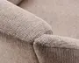 Nærbillede af en sofa-armlæn med tekstureret, vævet stof i en neutral beige farve. Polstringen har et diskret ternet mønster, som giver en blød og slidstærk overflade. Armlænet er let afrundet i kanterne, hvilket giver et moderne og komfortabelt udtryk.