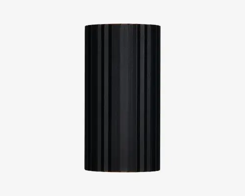Høj, cylindrisk genstand med mat sort overflade og lodrette riller jævnt fordelt rundt om hele overfladen. Designet er stilrent og moderne med en ensartet tekstur, der både giver et interessant udseende og et skridsikkert greb. Top og bund er flade, og det samlede udtryk er minimalistisk.