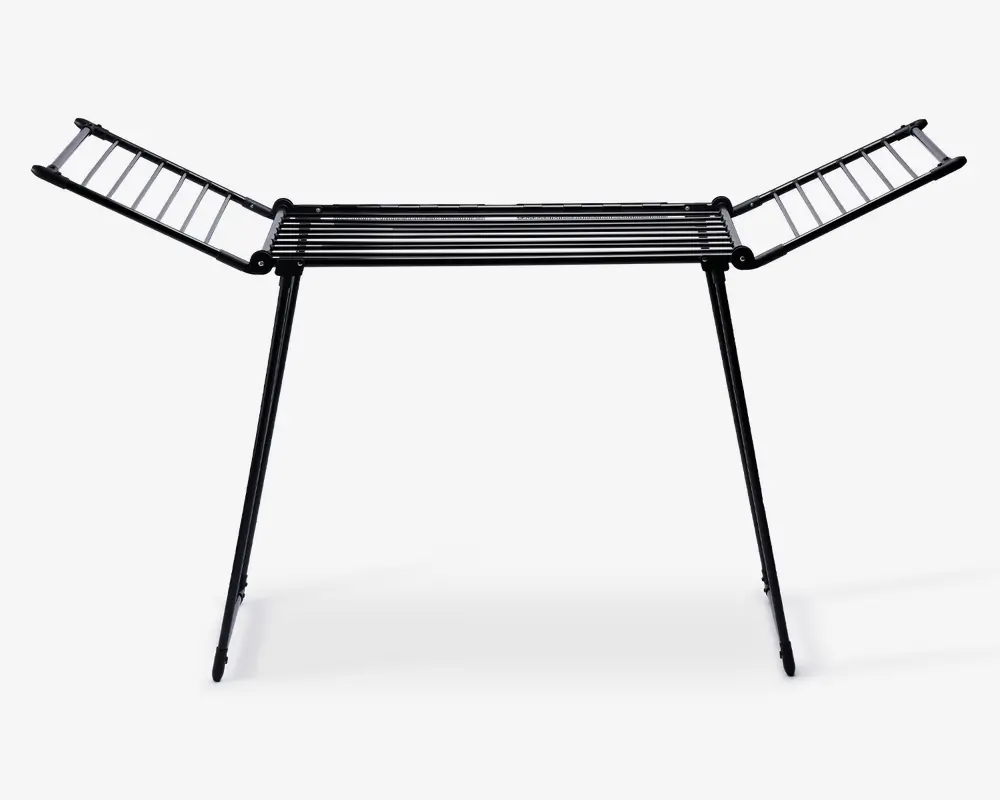 Et sammenklappeligt tørrestativ lavet af metal med sort finish. Det har en central sektion med parallelle stænger til at lægge tøj fladt, samt to sidevinger, der kan foldes ud for ekstra hængeplads. Stativet står på to skrå ben for stabilitet og kan foldes sammen for nem opbevaring.