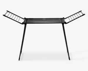 Et sammenklappeligt tørrestativ lavet af metal med sort finish. Det har en central sektion med parallelle stænger til at lægge tøj fladt, samt to sidevinger, der kan foldes ud for ekstra hængeplads. Stativet står på to skrå ben for stabilitet og kan foldes sammen for nem opbevaring.