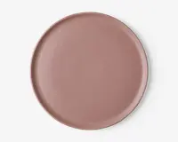 En rund, flad tallerken med en glat, mat overflade i en afdæmpet støvet rosa farve. Tallerkenen har en let hævet kant og et minimalistisk, moderne design uden mønstre eller dekorationer.