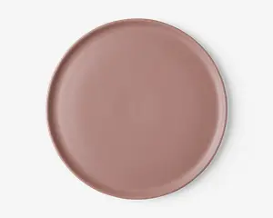 En rund, flad tallerken med en glat, mat overflade i en afdæmpet støvet rosa farve. Tallerkenen har en let hævet kant og et minimalistisk, moderne design uden mønstre eller dekorationer.