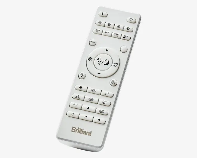 Hvid fjernbetjening med mange knapper, herunder dedikerede knapper til RGB-farveindstillinger, justering af lysstyrke og lysindstillinger som dagslys og nattilstand. Har mærkede knapper til gruppekontrol (A, B, C, D), timerfunktioner og en stor central cirkulær knap til lysstyrke og tilstand. 'Brilliant'-logoet er trykt nederst.