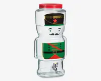 Gennemsigtig glasdrikkedispenser formet som en tinsoldat, med et trykt design der viser en grøn uniform, rød skråbånd, sort bælte og sort hat med gul kant og rød stjerne. Dispenseren har et rødt skruelåg øverst og en sølvfarvet tappehane nederst for nem udskænkning.