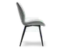 Sidevisning af en moderne stol med let buet, polstret ryglæn og sæde betrukket med et blødt, lysegråt stof. Stolen har slanke, skråtstillede sorte metalben, der giver et stilrent og minimalistisk udtryk. Sæde og ryglæn er sømløst forbundet og giver ergonomisk støtte samt et moderne design.