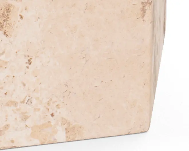 Nærbillede af et hjørne på et rektangulært objekt lavet af lys beige sten med naturlige variationer og diskrete plettede mønstre. Overfladen fremstår glat med synlig struktur og farveforskelle, hvilket giver et naturligt og jordnært udtryk.