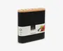 Rektangulær knivblok med mat sort krop og lyst trætop med flere slidser til knive. Blokken har en skridsikker bund for stabilitet og et moderne, minimalistisk design. Et mærkat omkranser midten og viser produktinformation samt billeder af friske grøntsager.