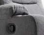 Nærbillede af en grå polstret lænestol med struktureret stof og et sort sidehåndtag til reclinerfunktion.
