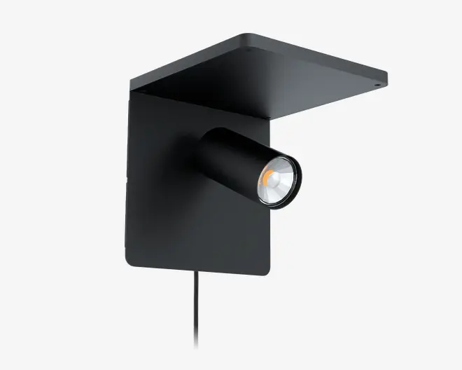 Et moderne, minimalistisk vægmonteret armatur med mat sort finish. Designet har en rektangulær bagplade med en flad, udhængende topplade og en cylindrisk, justerbar spotlampe, der stikker ud fra midten. Lampen har en synlig ledning, der går nedad fra basen.
