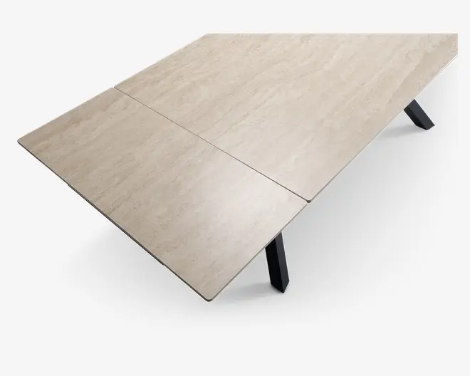 Rektangulær bordplade med en lys beige, marmorlignende overflade og diskrete årer. Overfladen er glat og ensartet, med en midterlinje der antyder, at bordet kan udvides. Bordpladen har let afrundede kanter og understøttes af solide, skråtstillede sorte ben.