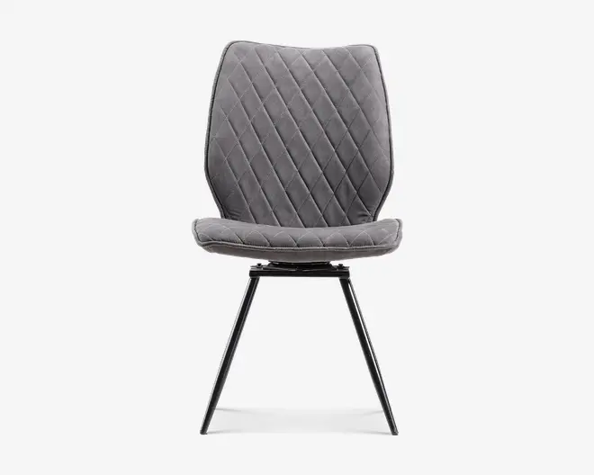 Grå polstret stol med ryg og sæde i diamantquiltet mønster, afrundet polstret sædekant og slanke sorte metalben med moderne, tilspidset design.
