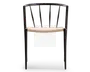 Stol med minimalistisk sort metalstel, rundet ryglæn og lodrette støttepinde. Sædet er flettet af lyst naturreb, hvilket giver en tekstureret og let buet siddeflade. Designet er moderne og let, med åbent rum mellem ryglænets stænger og slanke ben.