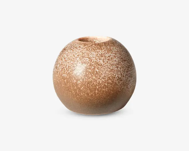 Rund, kugleformet keramikvase med en lille åbning i toppen. Overfladen har en plettet, tekstureret finish i varme brune og beige nuancer, hvilket giver et naturligt og jordnært udtryk. Vasens glasur er mat, og formen er glat og ensartet.