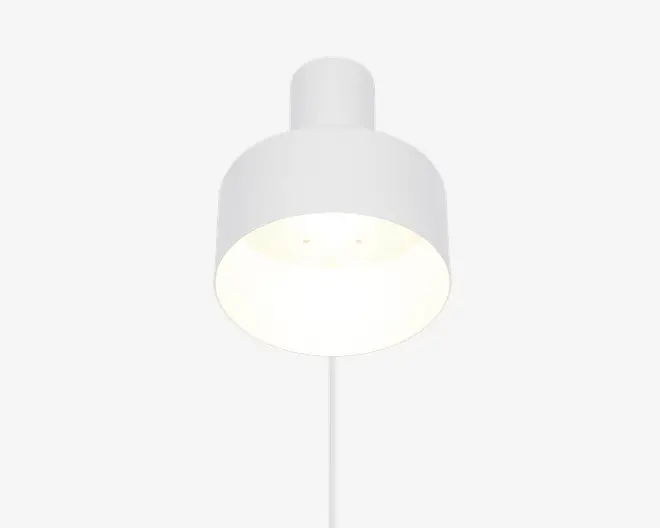En moderne, minimalistisk pendellampe med en glat, mat hvid overflade. Lampen har en cylindrisk top, der går over i en bred, rund skærm, som leder lyset nedad. Det enkle design og den neutrale farve gør lampen velegnet til mange forskellige indretninger.