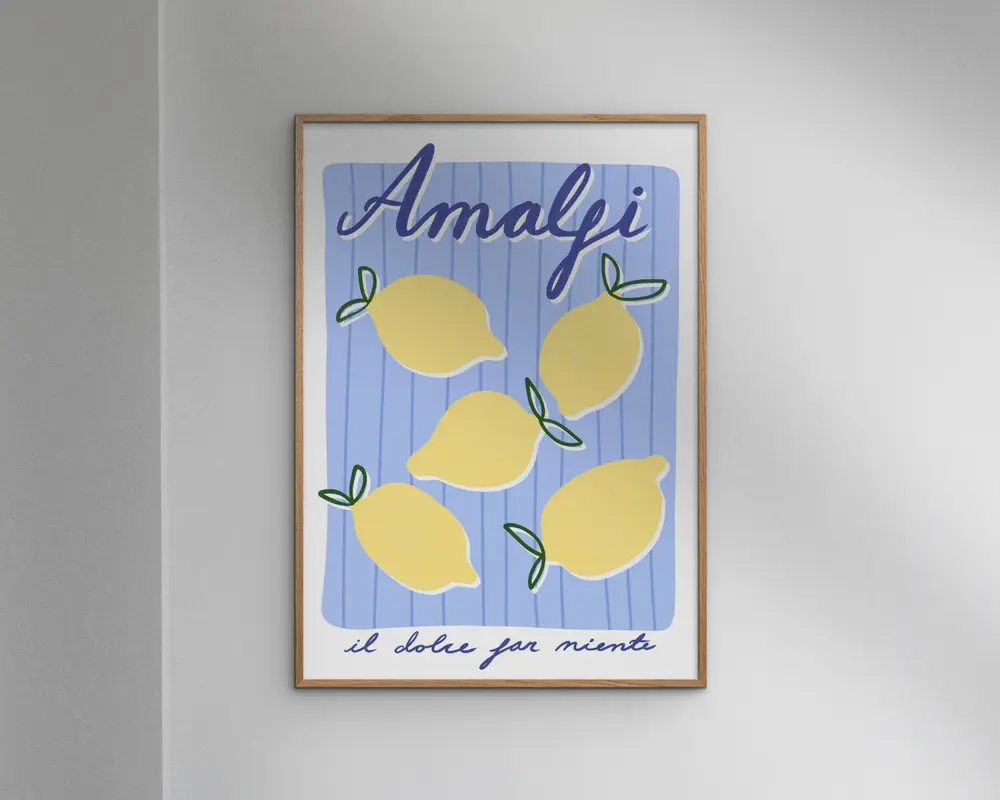 Indrammet kunsttryk med en legende illustration af fem gule citroner med grønne blade på en blå og hvidstribet baggrund. Øverst står ordet 'Amalfi' med store, blå, kursiverede bogstaver, og nederst ses sætningen 'il dolce far niente' med mindre håndskrift. Stilen er moderne og minimalistisk med en glad og sommerlig stemning.