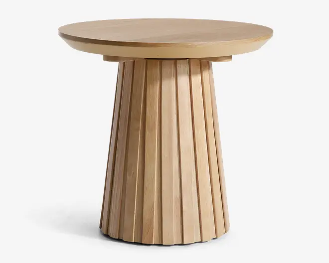 Rundt bord i træ med en resp, glat bordplade og en markant riflet søjleformet fod. Foden har lodrette riller, der giver struktur og visuel interesse. Træet har en lys, naturlig finish, som fremhæver åretegningen og giver et moderne, minimalistisk udtryk.