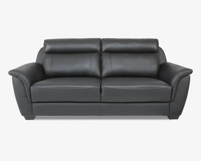 En moderne, mørkegrå lædersofa med brede, polstrede armlæn og bløde ryghynder. Sofaen har et stilrent, nutidigt design med rene linjer og synlige syninger. Sædehynderne er tykke og støttende, og ryglænet har let forhøjede nakkestøtter for ekstra komfort.