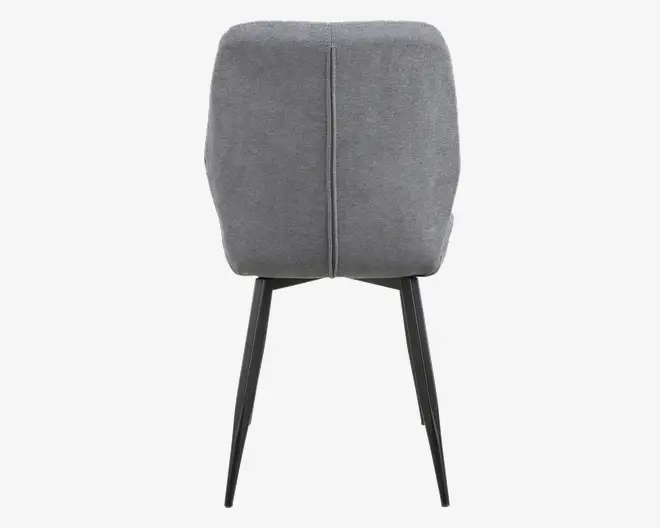 Billedet viser bagsiden af en stol med et blødt, gråt polstret ryglæn, der har en lodret syning i midten. Stolen har slanke, sorte metalben, som er let skråtstillede for stabilitet.