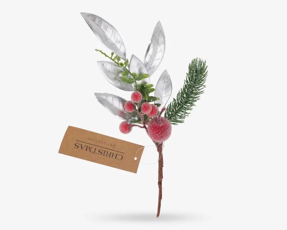 Kunstig dekorationsgren med frostede røde bær, en grangren, grønne blade og flere store sølvblade. Stilken er brun og har et mærke med teksten 'Christmas Decoration'. Udtrykket er festligt og vinterligt, velegnet til juledekorationer eller kreative projekter.