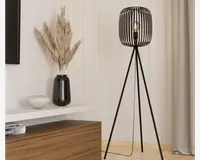 Høj gulvlampe med moderne design, sort metal skærm i bur-stil og tre slanke ben i tripod-form. Pæren er synlig inde i den åbne skærm, hvilket giver et industrielt udtryk. Lampen har et minimalistisk udseende, der passer til moderne indretning.