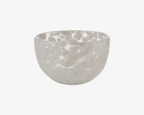 Rund skål med blank overflade, dekoreret med et diskret, uregelmæssigt hvidt og lysegråt plettet mønster over det hele. Skålen har glatte, buede sider og en let kraftig kant, hvilket giver et moderne og elegant udtryk.